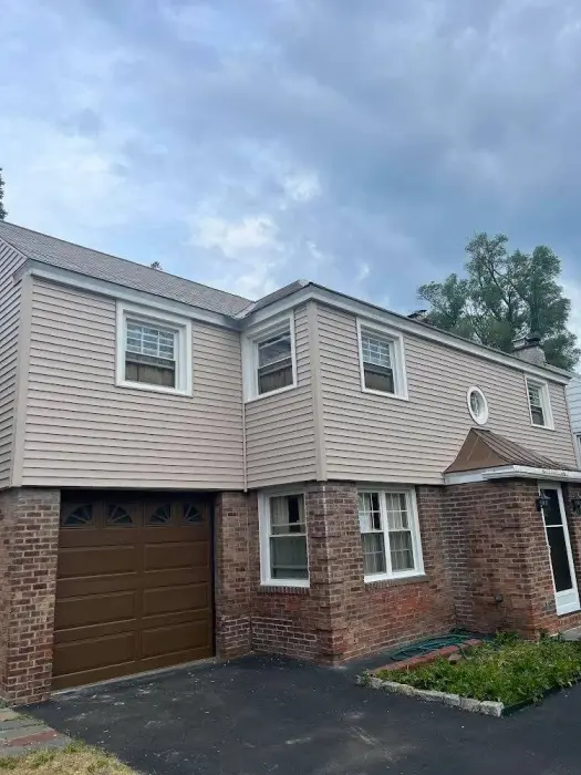 Two-story residential house with brick and beige siding.